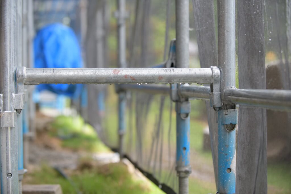 雨に濡れた建築現場の足場