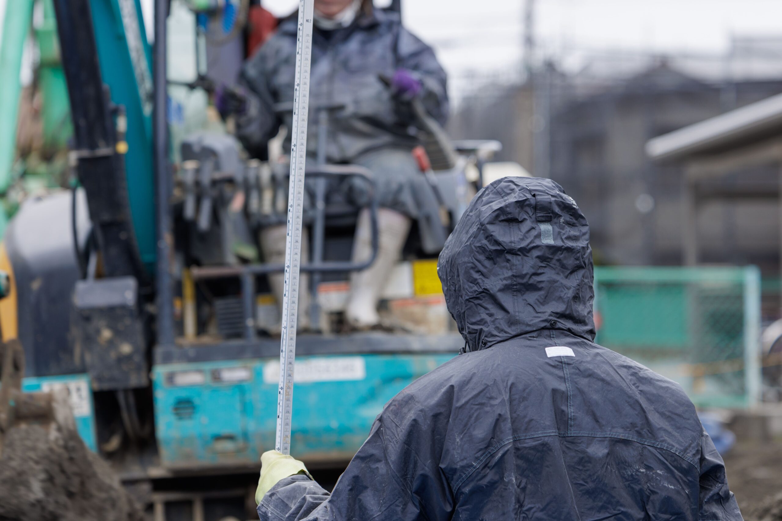 雨の中、建設工事をする作業員
